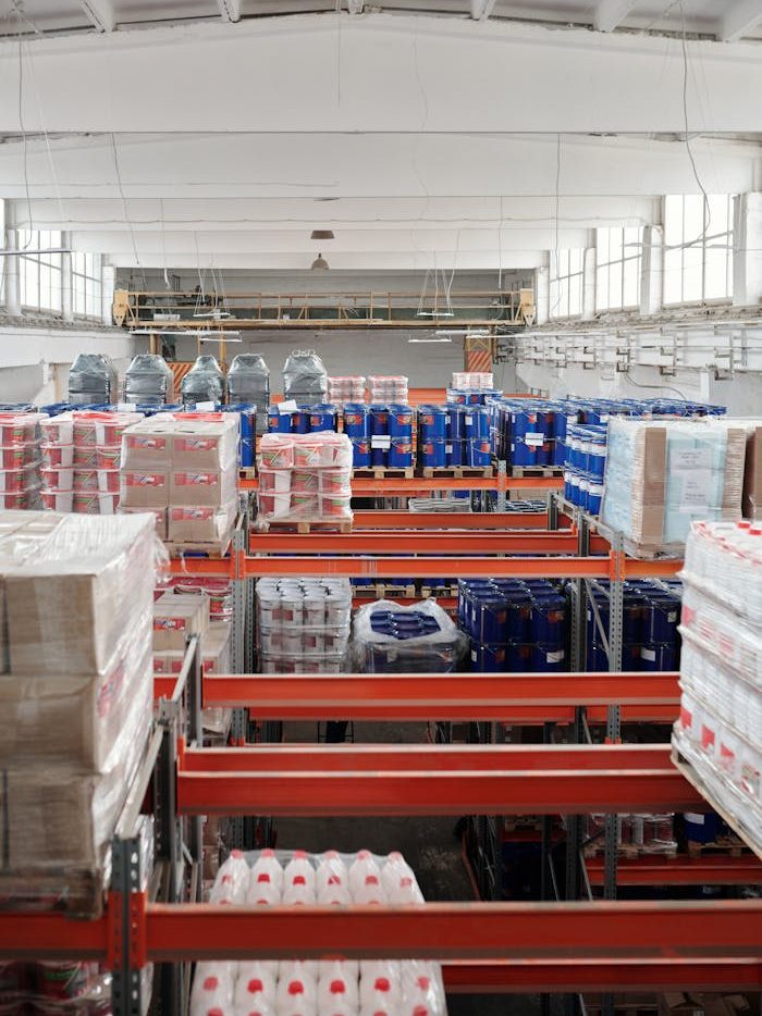 Interior of a large warehouse with neatly organized goods on shelves, ready for shipment.